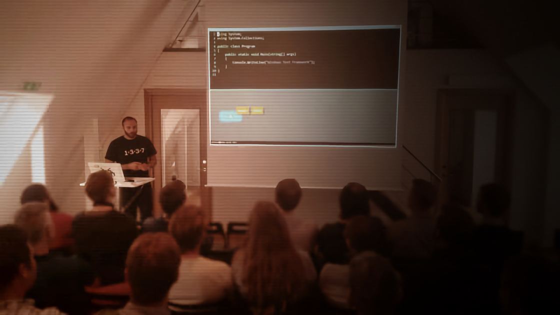 Enrico teaching a workshop to a small room, code on the projector